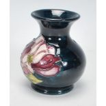 A Moorcroft vase of squat bulbous form. Tubelined decorated in the purple and white Magnolia