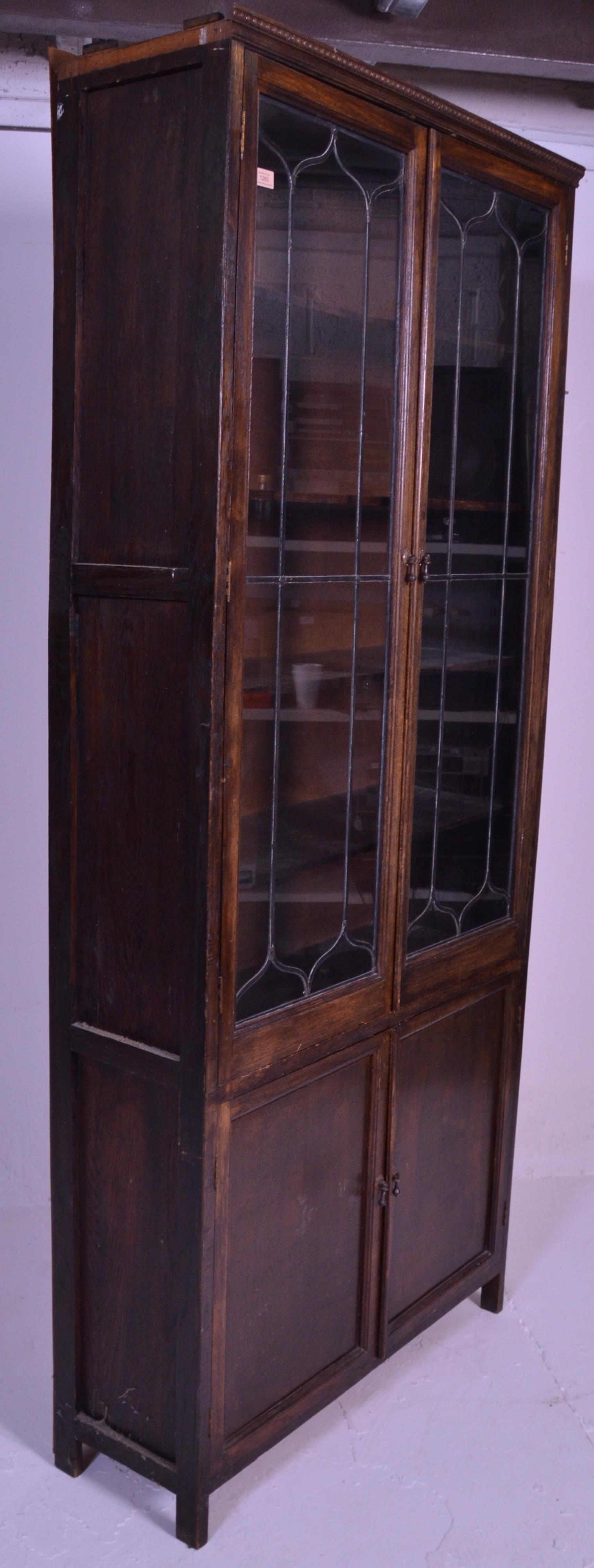 An early 20th Century 1920's oak bookcase having twin glazed lead lined glass doors over two oak - Image 3 of 5