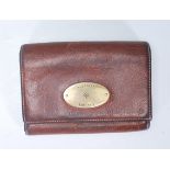 A vintage Mulberry ladies brown leather purse of folding design having a brass oval panel to the