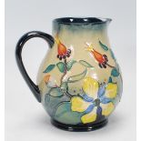 A Moorcroft jug of bulbous form in the Hypericum pattern, designed by Rachel Bishop. The jug with