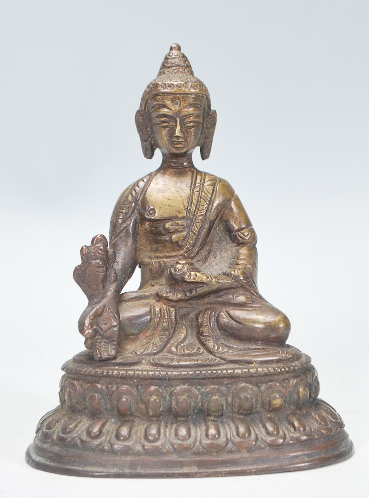 An Indian bronze figurine / ornament in the form of Buddha, modelled in a seated position raised
