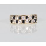 A 9ct gold ladies dress ring having two rows of alternate round cut sapphires and diamonds. Marked