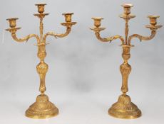 A good pair of late 19th / early 20th Century gilt brass three branchc candelabra candlesticks in