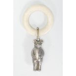 An early 20th Century Edwardian teething ring having a silver plated metal teddy bear charm in the