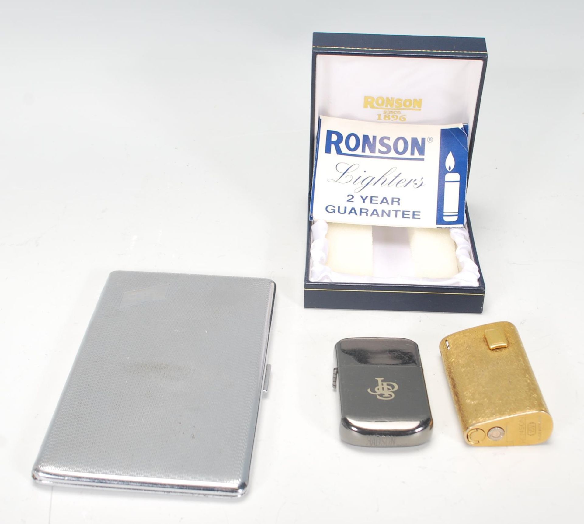 A vintage mid 20th Century Ronson 15V cigarette lighter having a gilt finish of curved triangular