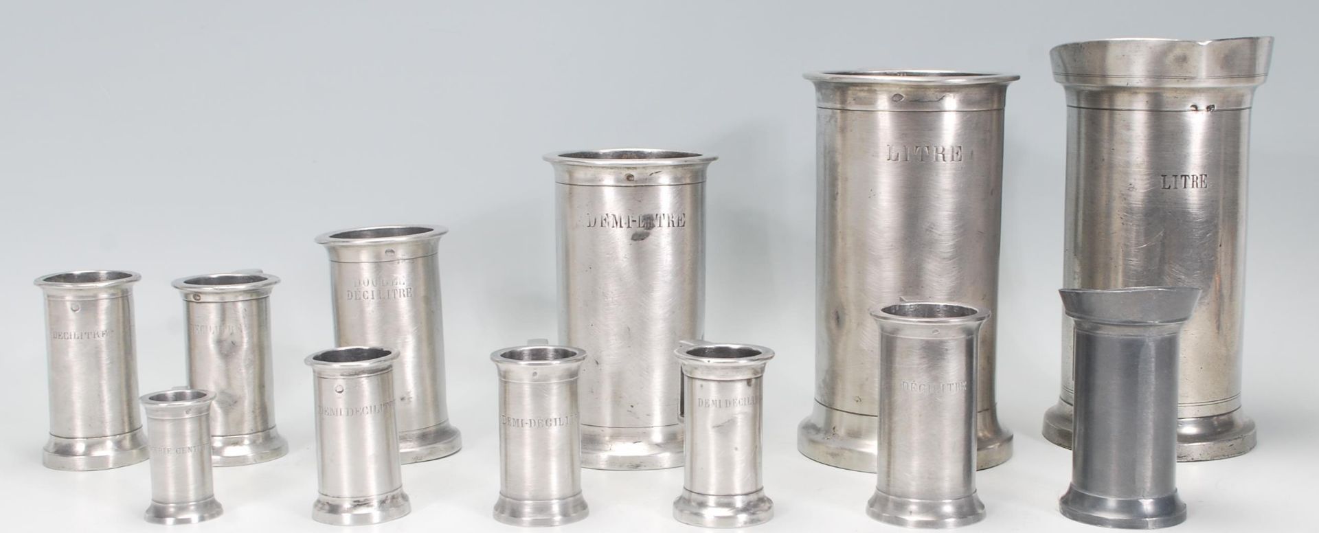 A group of 19th Century French pewter measuring tankards of graduating sizes. Many bearing stamps to - Bild 2 aus 10