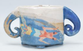 A vintage 20th Century studio art pottery cup having a central ovular form cup to centre with