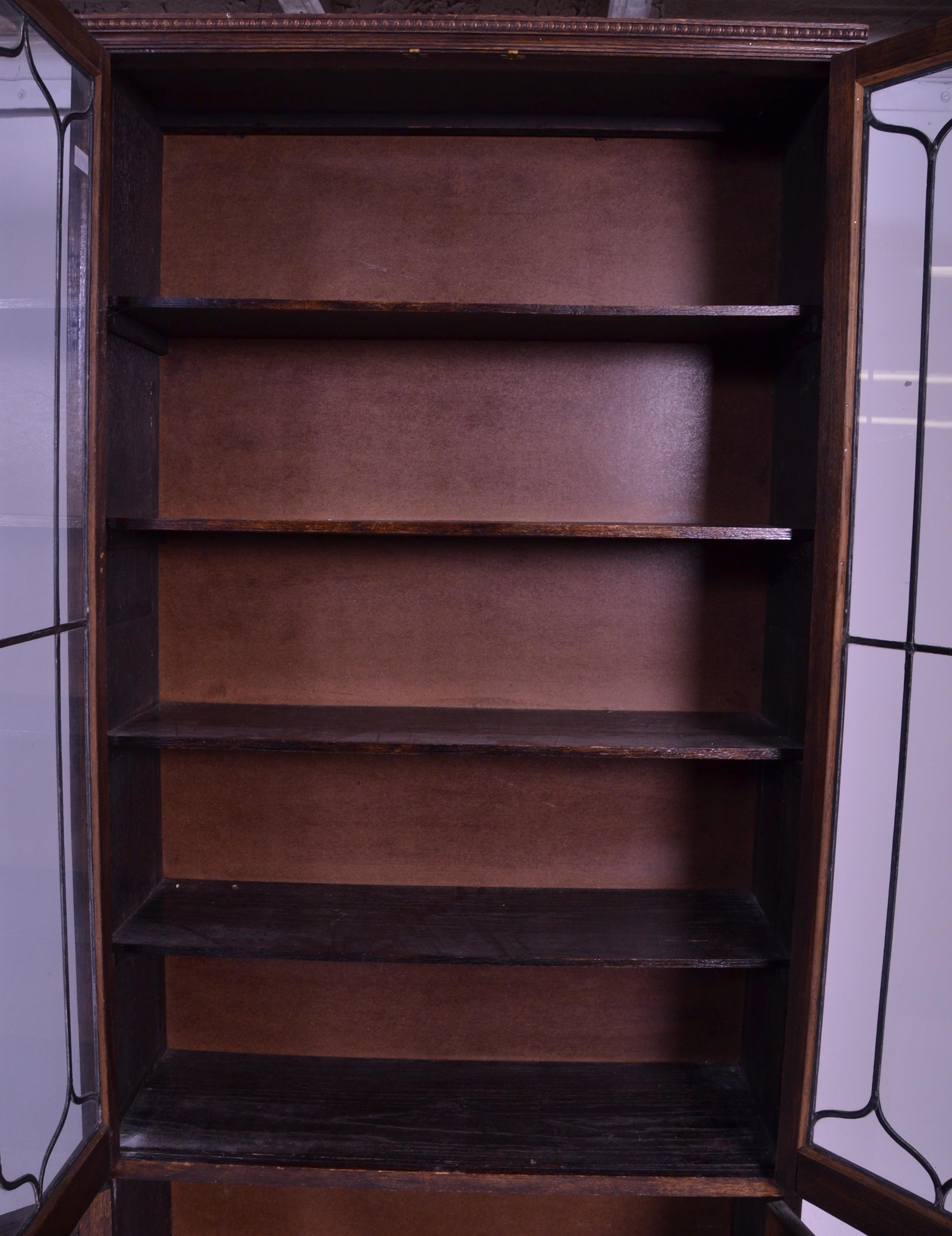 An early 20th Century 1920's oak bookcase having twin glazed lead lined glass doors over two oak - Image 4 of 5