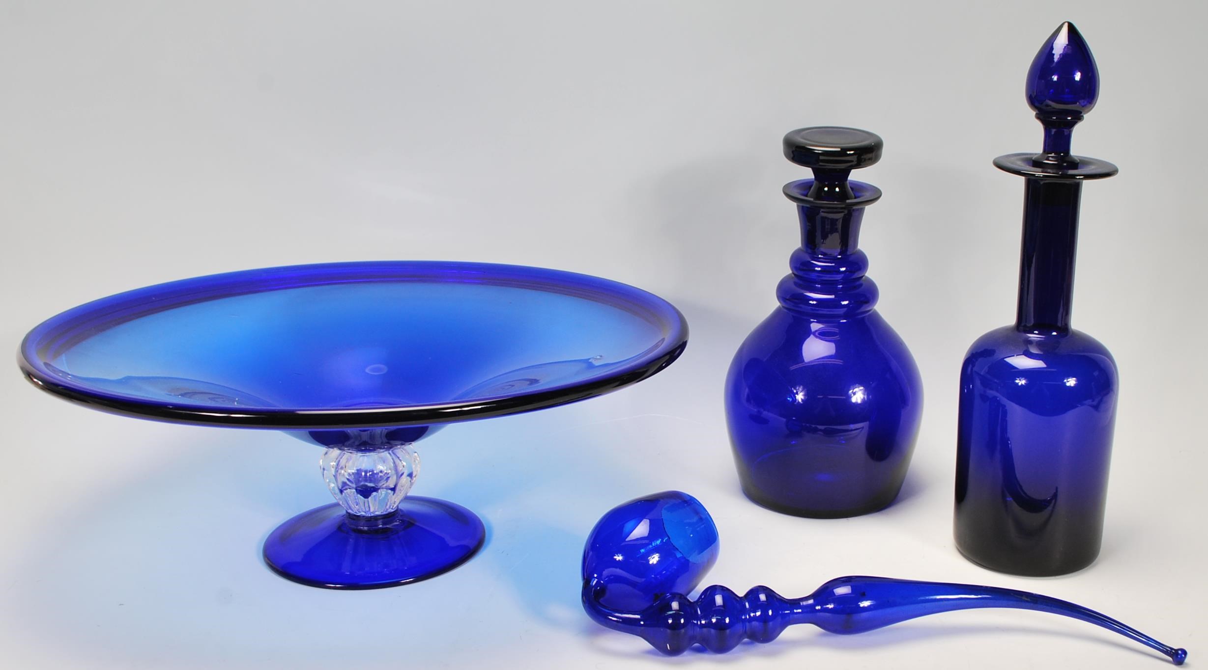 A group of Bristol blue glassware to include two decanters one of bell shaped form and the other