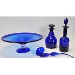 A group of Bristol blue glassware to include two decanters one of bell shaped form and the other