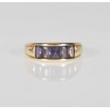 A 9ct yellow gold ladies ring having a split mount set with rectangular faceted cut purple stones