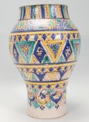 A late 19th / early 20th Century Moroccan pottery vase of waisted form having hand painted