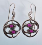 A pair of round snake like drop earrings having th