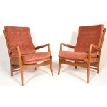 A pair of mid century teak wood Cintique armchairs. Each raised on show wood a-frames with