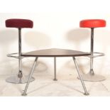 A pair of vintage bar stools having round upholstered cushions raised on a chromed columns with foot