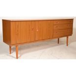 A vintage 1970's retro faux teak wood veneer sideboard credenza being raised on tapering legs with a