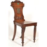 An early 19th century George III mahogany hall chair being raised  on hexagonal turned legs with
