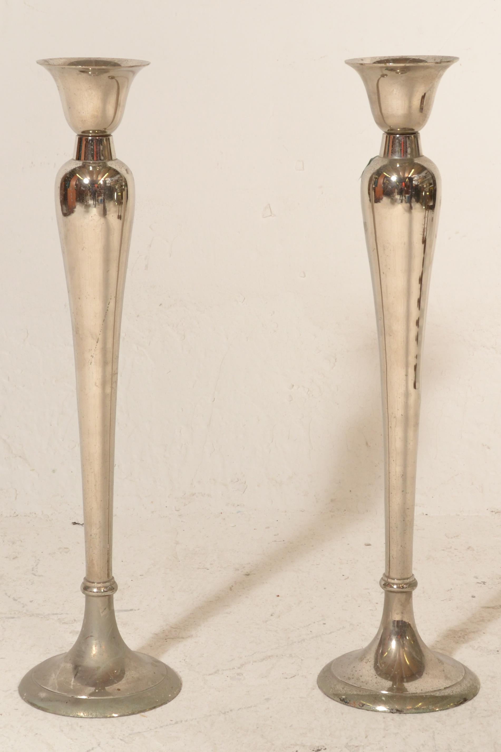 A pair of 20th Century silver tone candlesticks having rounded tapering stems with circular bases