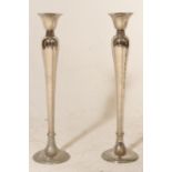 A pair of 20th Century silver tone candlesticks having rounded tapering stems with circular bases