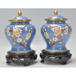 A pair of 20th Century Chinese cloisonne vases of bulbous waisted form having lidded tops with