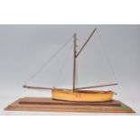 A good quality early 20th Century wooden built model boat having a single mast adorned with ropes,