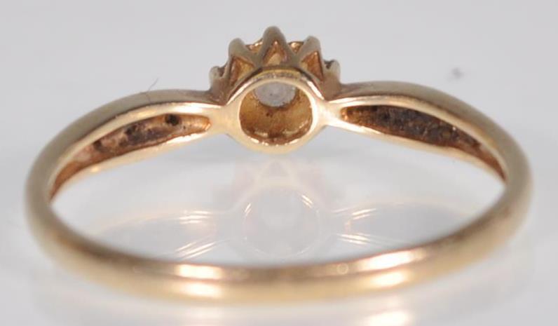 A hallmarked 9ct yellow gold ladies ring having a central round cut diamond set within a starlike - Image 4 of 7