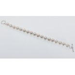 A freshwater pearl bracelet set with cubit zirconia held together with a silver clasp. Gross