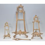 A graduating set of three contemporary Rococo style brass table easels having acanthus and scroll