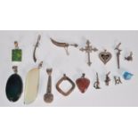 A selection of silver pendant and charms to include a crucifix pendant set with white stones, a