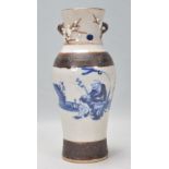 A 19th Century Chinese Guangxu crackle glaze vase being hand painted in blue and white with a seated