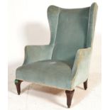 An Edwardian mahogany wingback armchair. Raised on cabriole stub legs with turquoise upholstered