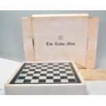 A Tudor Mint 'Combatants' Chess Set having a glass chess board with black and silver spaces with the