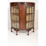 A 1930's mahogany Queen Anne revival demi lune display china cabinet vitrine being raised on claw