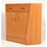 A 1960’s oak Ernest Gomme secretaire corner cabinet with pull out drawer desk over cupboard. All