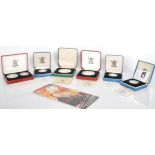 A group of silver proof coins to include two 1990 pound coins, a 1986 one pound coin, and a 1990