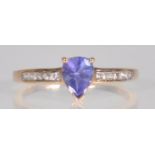An English hallmarked 9ct yellow gold ladies ring set with a central teardrop faceted cut purple