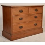 An early 20th Century walnut chest of drawers raised on a plinth base having two short drawers of