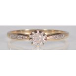 A hallmarked 9ct yellow gold ladies ring having a central round cut diamond set within a starlike