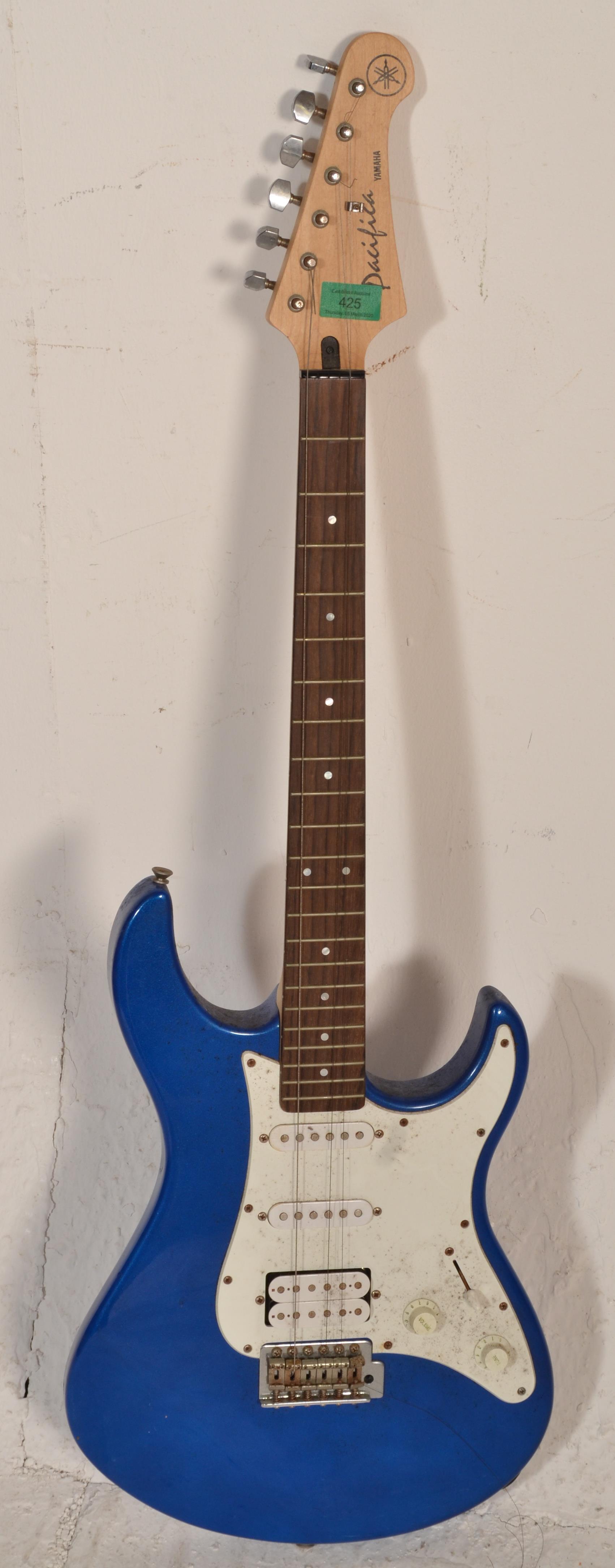 A Yamaha Pacifica stratocaster style electric guitar having a blue painted body with a white
