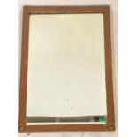 A 20th Century Arts and Crafts style wall mirror of rectangular form having bevelled glass with a
