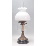 A 19th Century Victorian oil lamp raised on a round ebonised base with a reeded column, glass