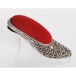 A sterling silver pin cushion in the form of a ladies high heeled shoe having a red velvet cushion