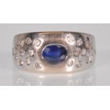An English hallmarked 18ct white gold ladies ring set with a central oval cut blue stone flanked