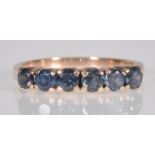 A 9ct yellow gold ladies dress ring set with six faceted round cut blue stones. Gross weight 2.4g.