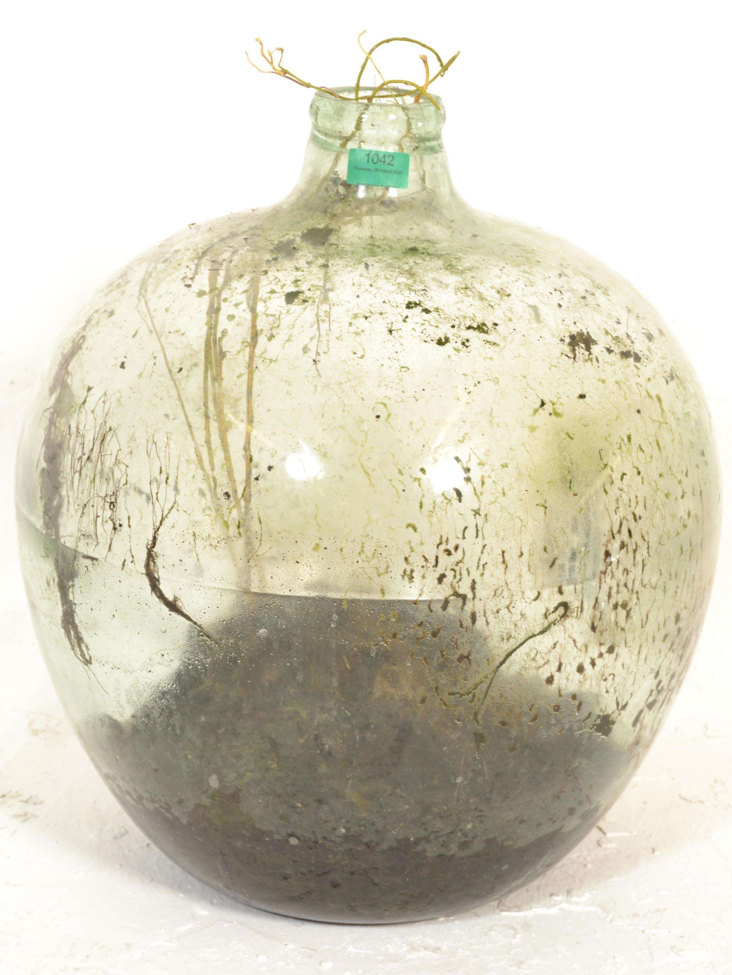 A vintage early 20th century large green glass acid carboy bottle  of globe form with waisted neck