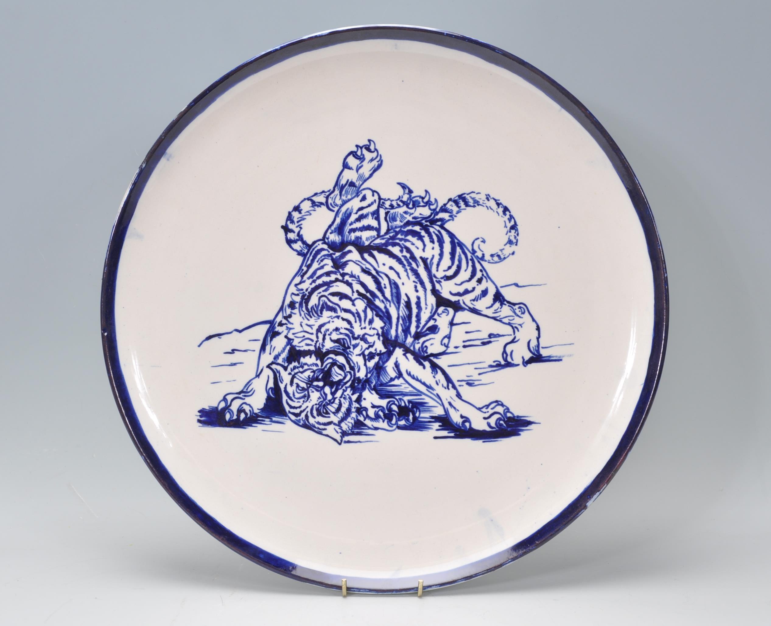 A large early 20th Century English blue and white charger plate in the manor of Frederick Rhead