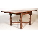A 1940's oak draw leaf refectory dining table being raised on candy twist upright legs with block