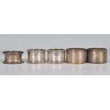 A group of five silver hallmarked napkin rings to include a pair of cylindrical form rings with