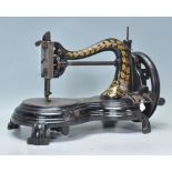 A Victorian 19th century Jones sewing machine of scroll form with crank wheel to end. Good gilded