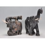 An early 20th Century carved ebonised wooden figure depicting an elephant fighting two tigers with